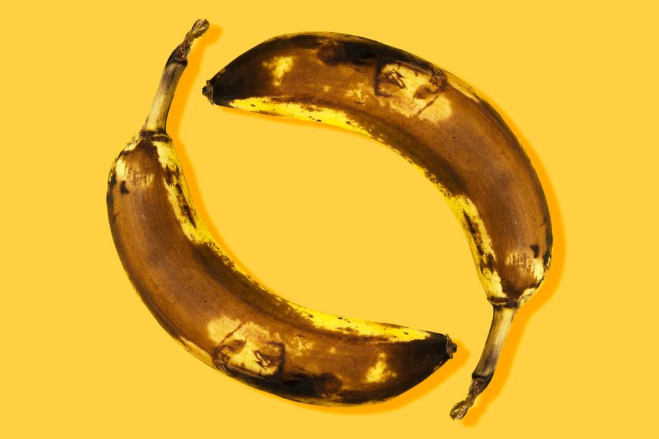 two brown bananas on a yellow background