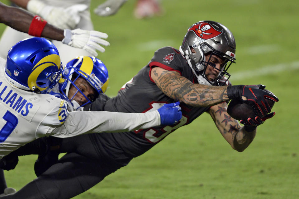 Tampa Bay Buccaneers wide receiver Mike Evans (13) slips a tackle by Los Angeles Rams defensive back Darious Williams (31) to score during the first half of an NFL football game Monday, Nov. 23, 2020, in Tampa, Fla. (AP Photo/Jason Behnken)