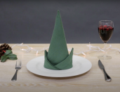<p>Whether you go with a green, red or blue napkin, you can recreate this funny elf hat napkin in less than one minute. Start by folding your napkin in half, then roll it. Fold up the bottom to form the brim of the hat, and you're finished!</p><p><em><a href="https://www.youtube.com/watch?v=zcCPmOs5-SQ" rel="nofollow noopener" target="_blank" data-ylk="slk:Get the tutorial »" class="link ">Get the tutorial »</a></em></p>