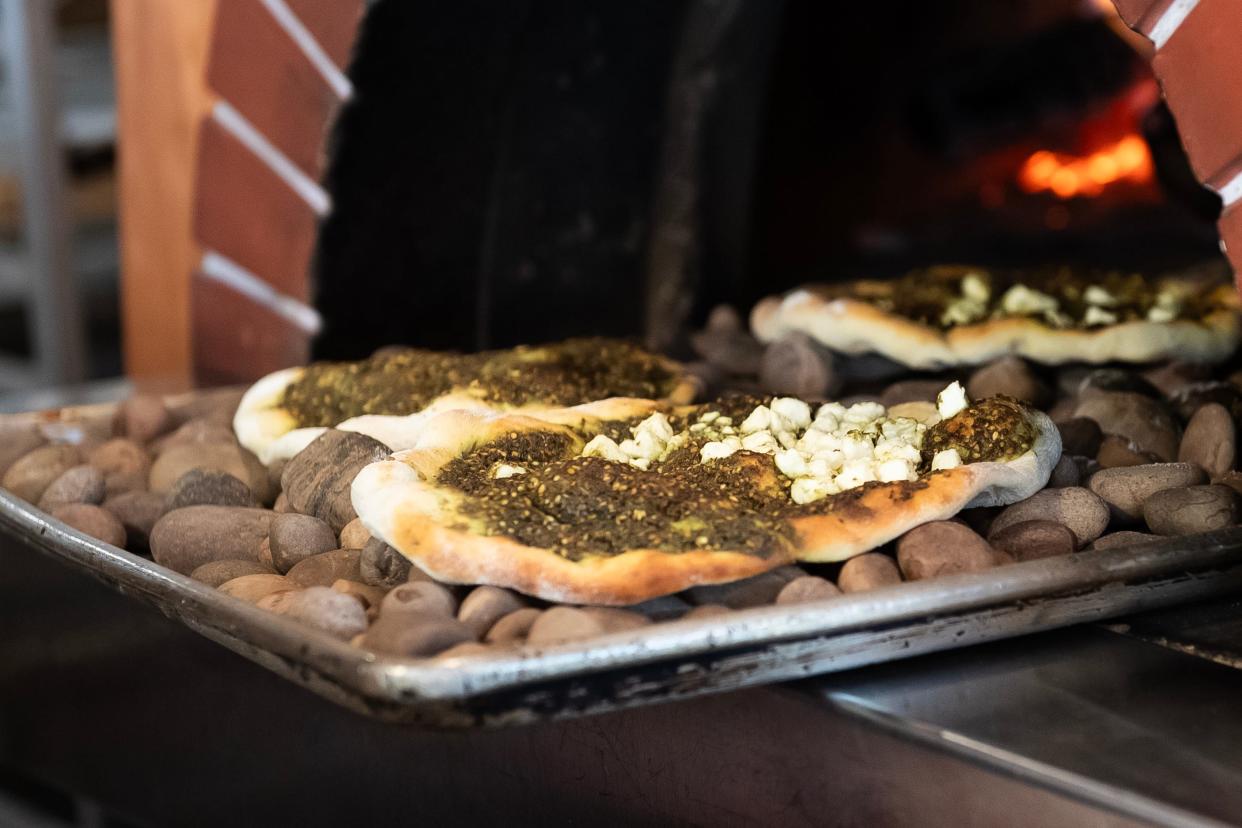 Freshly-baked manakish za'atar are pulled from the wood-fired oven at Levant Mediterranean Cuisine in York's Royal Square District on Thursday, June 27, 2024.