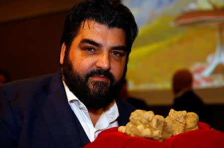 Italian chef Antonino Cannavacciuolo holds a set of truffles weighing 850 grams during the international auction for truffles at the Grinzane Castle in Grinzane Cavour near Alba, Italy, November 12, 2017. REUTERS/ Stefano Rellandini