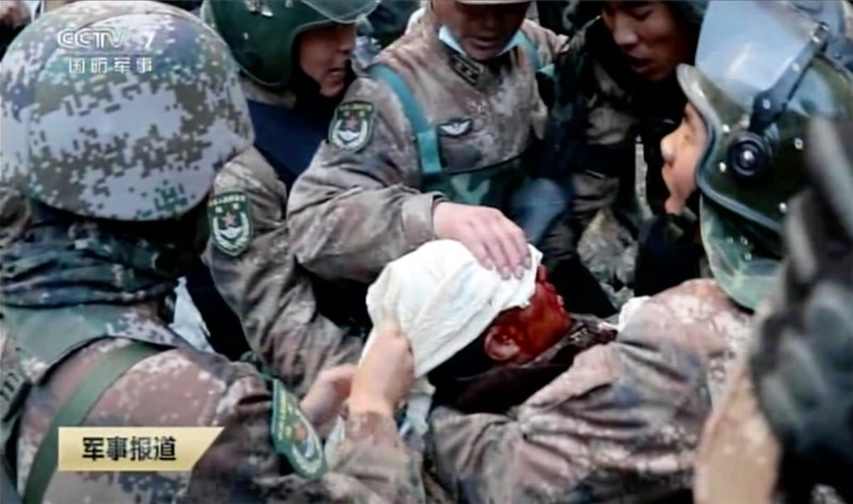 In this image taken from video footage run 19 February 2021 by China's CCTV via AP Video, soldiers bandage the head of China's People’s Liberation Army (PLA) regimental commander Qi Fabao (CCTV)