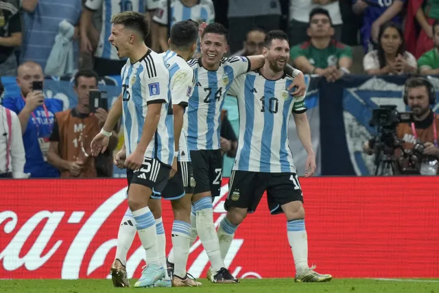 Argentina's Enzo Fernandez, second from right, celebrates with his teammate Lionel Messi, right, during the World Cup group C soccer match between Argentina and Mexico, at the Lusail Stadium in Lusail, Qatar, Saturday, Nov. 26, 2022. (AP Photo/Jorge Saenz)