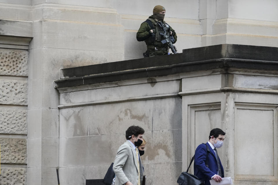 A member of the Georgia State Patrol SWAT team looks on as people walk by outside of the Georgia State capitol after the opening day of the legislative session on Monday, Jan. 11, 2021, in Atlanta. State capitols across the country are under heightened security after the siege of the U.S. Capitol last week. (AP Photo/Brynn Anderson)