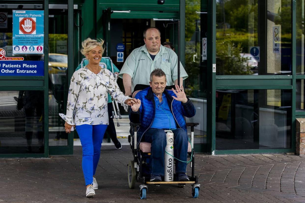 <span class="caption">Geoffrey McKillop (front) with his partner Nicola Dallet McConaghie as they left the hospital where he was discharged after surviving coronavirus. </span> <span class="attribution"><a class="link " href="https://www.gettyimages.com/detail/news-photo/geoffrey-mckillop-with-his-partner-nicola-dallet-mcconaghie-news-photo/1213058444?adppopup=true" rel="nofollow noopener" target="_blank" data-ylk="slk:Liam McBurney/PA Images via Getty Images;elm:context_link;itc:0;sec:content-canvas">Liam McBurney/PA Images via Getty Images</a></span>