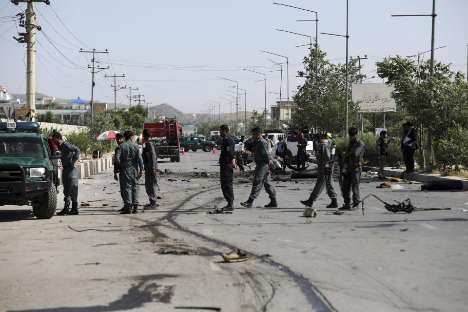 Afghan security personnel inspect the site of a bomb explosion in Kabul, Afghanistan, Thursday, June 3, 2021. Police say a bomb has ripped through a minivan in the western part of the Afghan capital Kabul, killing at least four people. No one took responsibility for the attack in the neighborhood, which is largely populated by the minority Hazara ethnic group who are mostly Shiite Muslims. (AP Photo/Rahmat Gul)