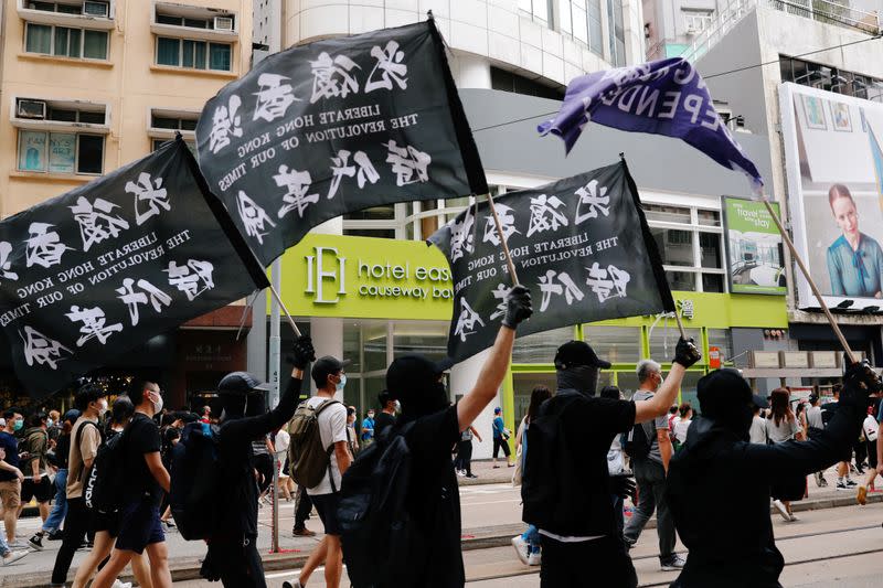 Manifestantes sostienen banderas negras llamando a la independencia de Hong Kong durante una protesta en abierto desafío a las leyes de seguridad de China. Hong Kong, China. Julio 1, 2020. REUTERS/Tyrone Siu