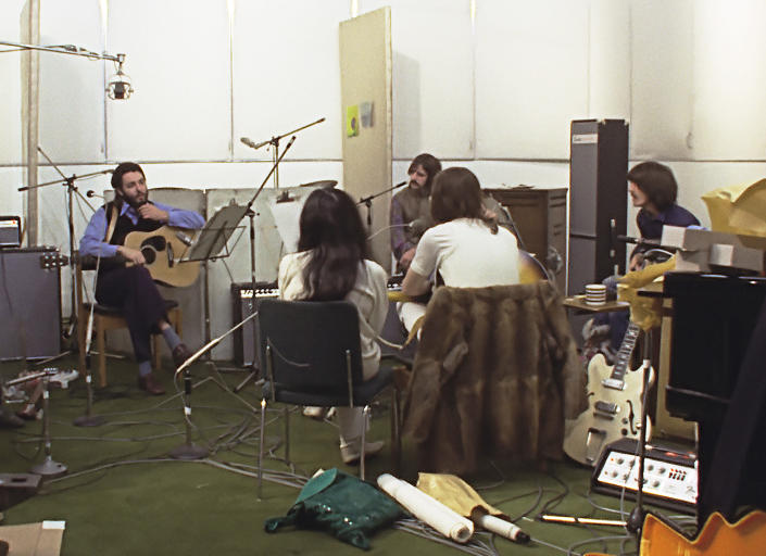 This image released by Disney+ shows, background from left, Paul McCartney, Ringo Starr and George Harrison, and foreground from left, Yoko Ono and John Lennon in a scene from the nearly 8-hour Peter Jackson-produced documentary “Get Back,” airing over three days starting Thanksgiving. (Disney+ via AP)