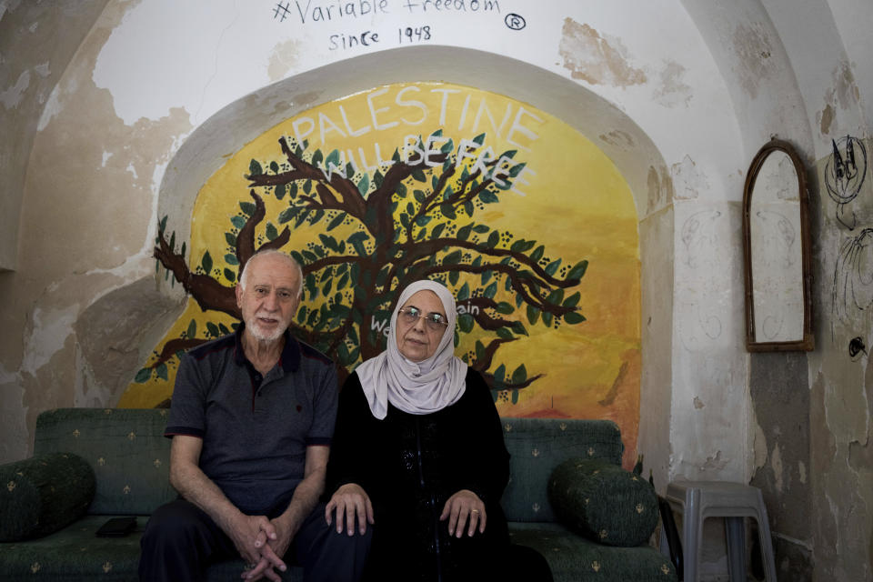 Nora and Mustafa Ghaith-Sub Laban pose for a portrait in their home in the Old City of Jerusalem Wednesday, June 21, 2023. The family has battled Israeli attempts to force them out for the past 45 years. The campaign ended this spring, when the Israeli Supreme Court struck down their final appeal in favor of Jewish settlers contending they violated the lease. Now, Israeli authorities have ordered the eviction of the family to take place by July 13. (AP Photo/Maya Alleruzzo)