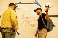 As the KNP Complex Fire burns nearby, U.S. Forest Service operations section chief Casey Cheesbrough speaks with private firefighter Jake Heckathorn of Wildfire Defense Systems in Sequoia National Park, Calif., on Wednesday, Sept. 15, 2021. The blaze is burning near the Giant Forest, home to more than 2,000 giant sequoias. (AP Photo/Noah Berger)