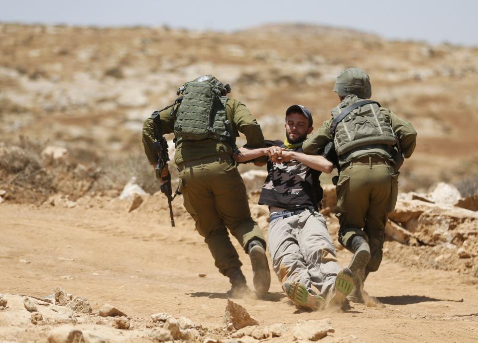 Israeli forces remove a demonstrator July 1 in the West Bank.