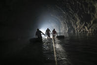 Hombres equipados con flotadores vadean el agua acumulada en un túnel abandonado con la ayuda de una línea de seguridad mientras trabajan en al reparación de una canalización de agua creada por ellos, en el vecindario Esperanza, en Caracas, Venezuela, el 11 de junio de 2020. El suministro de agua en Venezuela es tan precario que en vecindarios pobres empiezan a gestionar canalizaciones privadas o a excavar pozos poco profundos. (AP Foto/Matías Delacroix)