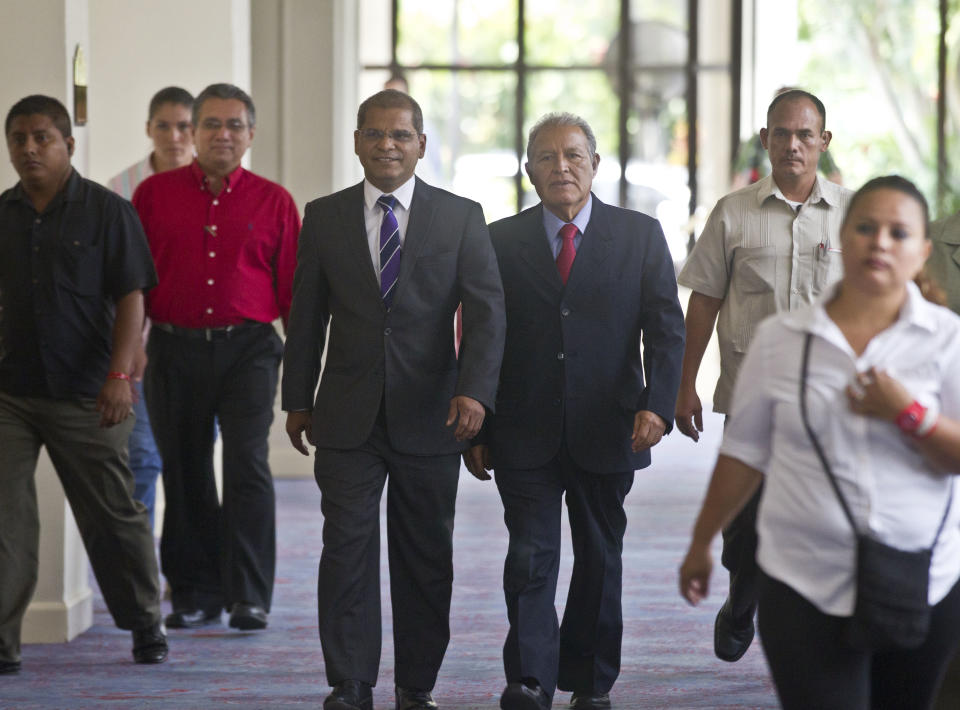 Presidential candidate Salvador Sanchez Ceren of the ruling Farabundo Marti National Liberation Front (FMLN), right, and running mate Oscar Ortiz arrive for a press conference in San Salvador, El Salvador, Monday, March 10, 2014. El Salvador's too-close-to-call presidential runoff election has raised competing claims of victory from Ceren, a former fighter for leftist guerrillas and Norman Quijano, candidate of the once long-ruling conservative party that fought a civil war from 1980 to 1992. (AP Photo/Esteban Felix)