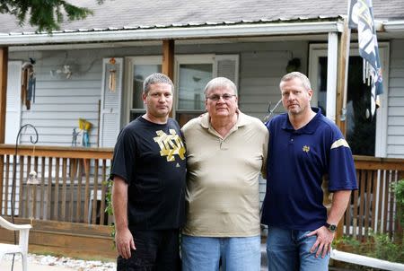 Bruce Reynolds (C) with sons Robert (L) and Bruce Jr., who were once all employed by the now shuttered BorgWarner factory, stand in front of Bruce Reynolds Senior's home in Muncie Indiana, U.S., August 13, 2016. REUTERS/Chris Bergin