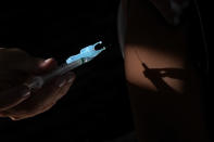 A health worker applies a shot of the Pfizer COVID-19 vaccine at a community health center in Brasilia, Brazil, Sunday, Jan. 16, 2022. Brasilia started the COVID-19 vaccination of children between ages 5 and 11. (AP Photo/Eraldo Peres)