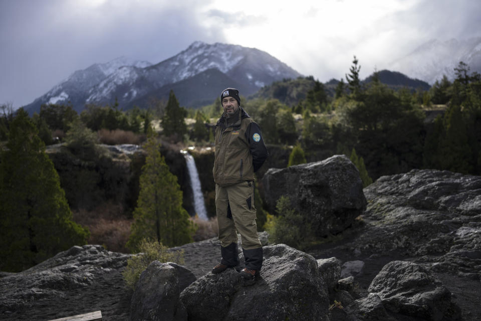 Mapuche leader Victor Curin, a Conguillio National Park ranger, poses for a portrait near a waterfall at the headwaters of the Truful Truful River in the Andes of southern Chile on Monday, July 11, 2022. "Human beings feel superior to the space where they go, but for us Mapuche, I belong to the earth, the earth doesn't belong to me," he says. (AP Photo/Rodrigo Abd)