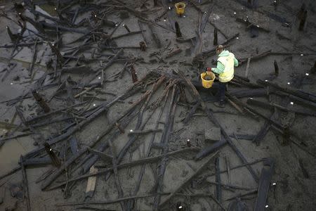 Archaeologists from the University of Cambridge Archaeological Unit, uncover Bronze Age wooden houses, preserved in silt, from a quarry near Peterborough, Britain, January 12, 2016. REUTERS/Peter Nicholls