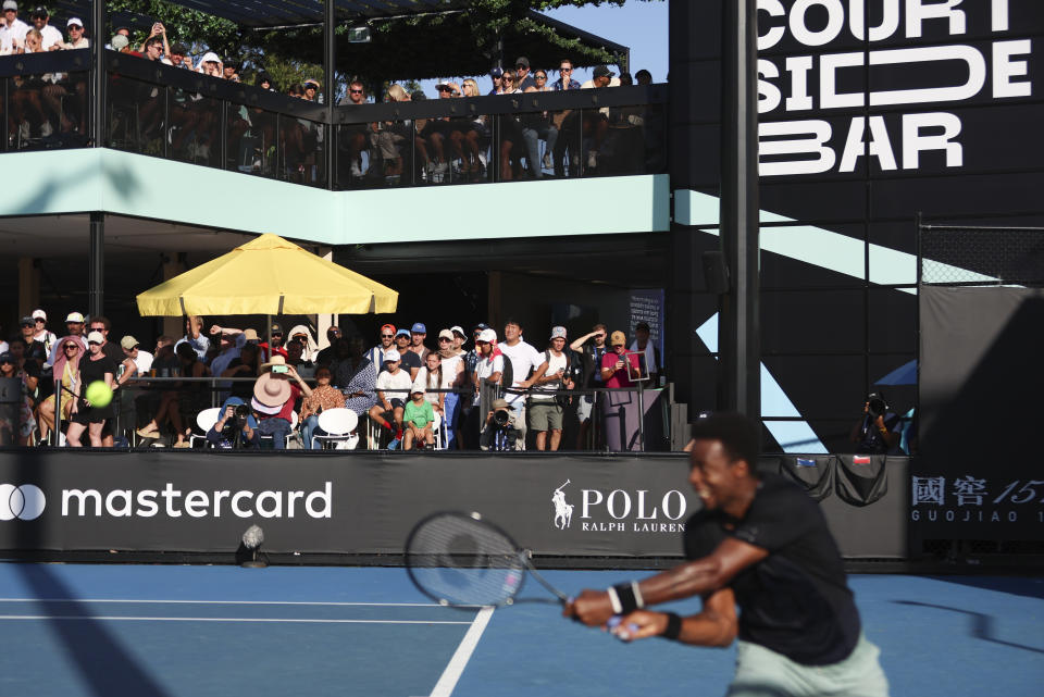 Fans watch France's Gael Monfils first round match from a bar overlooking court 6 at the Australian Open tennis championships at Melbourne Park, Melbourne, Australia, Monday, Jan. 15, 2024.There's a certainly a buzz around the bar that overlooks Court 6 and gives Australians Open fans a shady place to have a cool drink on a hot day, which is something of a national tradition. It's popular with fans but the music and constant movement adjacent to a Grand Slam tennis court is dividing opinion among players. (AP Photo/Asanka Brendon Ratnayake)