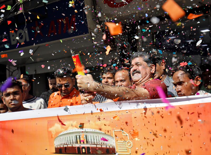 People, who claim to have migrated from Pakistan's Sindh Province, blow confetti to celebrate after India's parliament passed a Citizenship Amendment Bill, in Ahmedabad