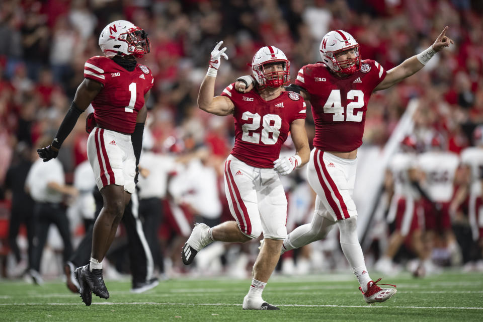 Nebraska defensive back Tyreke Johnson (1), Nebraska linebacker Luke Reimer (28) and Nebraska linebacker Nick Henrich (42) celebrate after making a stop in the 4th quarter during an NCAA football a game between Nebraska and Indiana, Saturday, Oct. 1, 2022 at Memorial Stadium in Lincoln, Neb. (Noah Riffe/Lincoln Journal Star via AP)