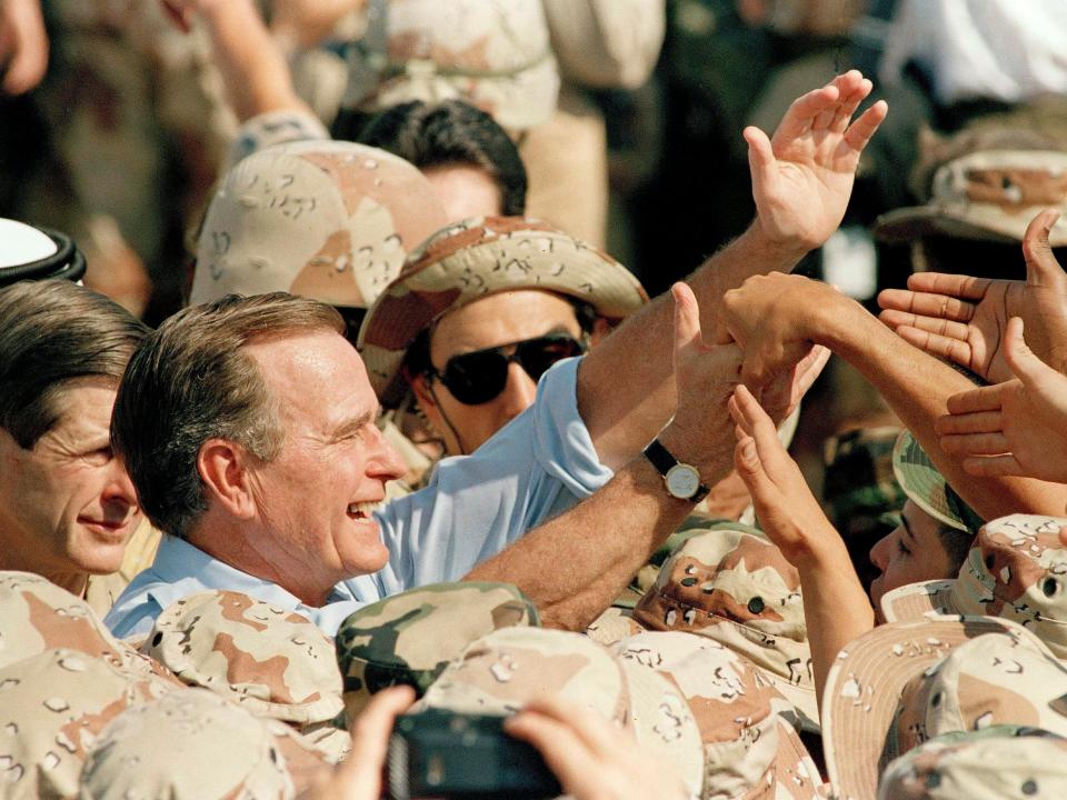 Bush salutes troops in Saudi Arabia.