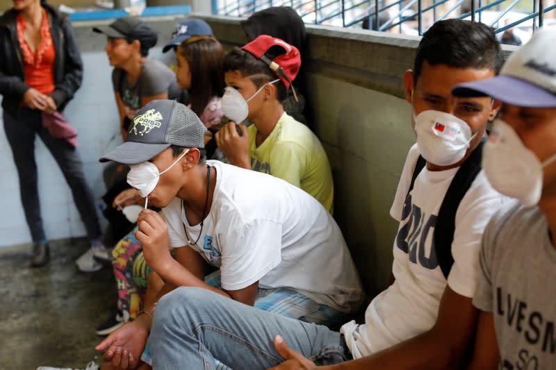 People outside a metro station wear face masks distributed by members of the Taiwan and Venezuela Parliamentary Friendship team, in response to the spreading coronavirus (COVID-19), in Caracas