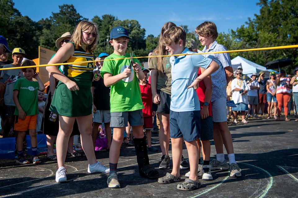 Noah Harris, Karen Cragnolin’s grandson, cuts a ribbon during the dedication of Karen Cragnolin Park August 25, 2023.