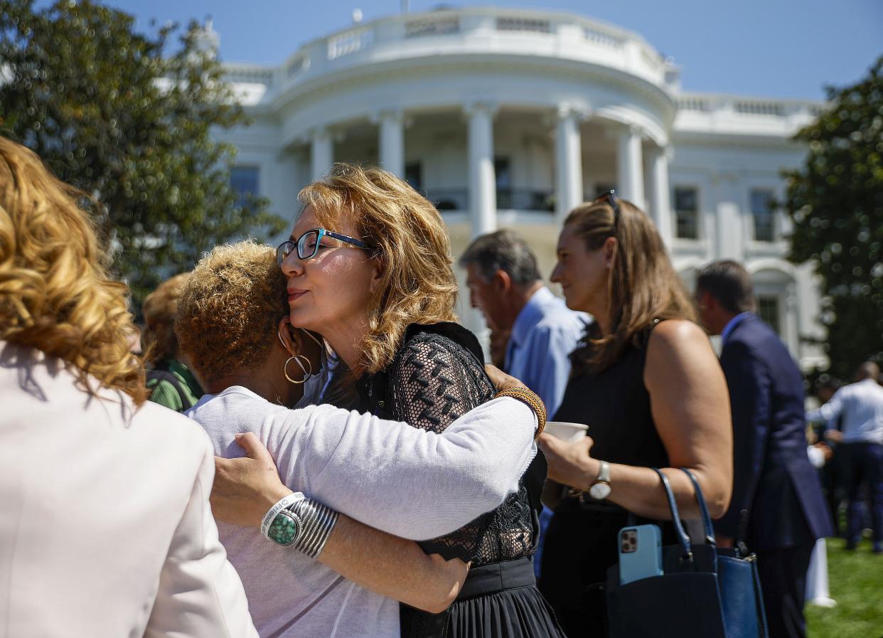 Gabby Giffords, former U.S. Representative and mass shooting survivor, hugs an audience member during an event to celebrate the Bipartisan Safer Communities Act on the South Lawn of the White House on July 11, 2022 in Washington, DC. 