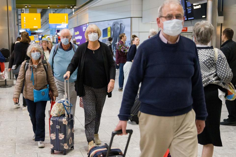 Travellers who had been aboard the Braemar cruise ship, operated by Fred Olsen Cruise Lines, and wearing face masks as a precautionary measure against covid-19, react as they arrive at Heathrow Airport in London on March 19, 2020, after being flown back from Cuba. - The MS Braemar had more than 1,000 people aboard including five confirmed coronavirus cases and more than 50 people in isolation due to showing flu-like symptoms. (Photo by Tolga AKMEN / AFP) (Photo by TOLGA AKMEN/AFP via Getty Images)