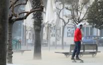 Man rides his skateboard during the storm "Gloria" in front of Barceloneta Beach, in Barcelona