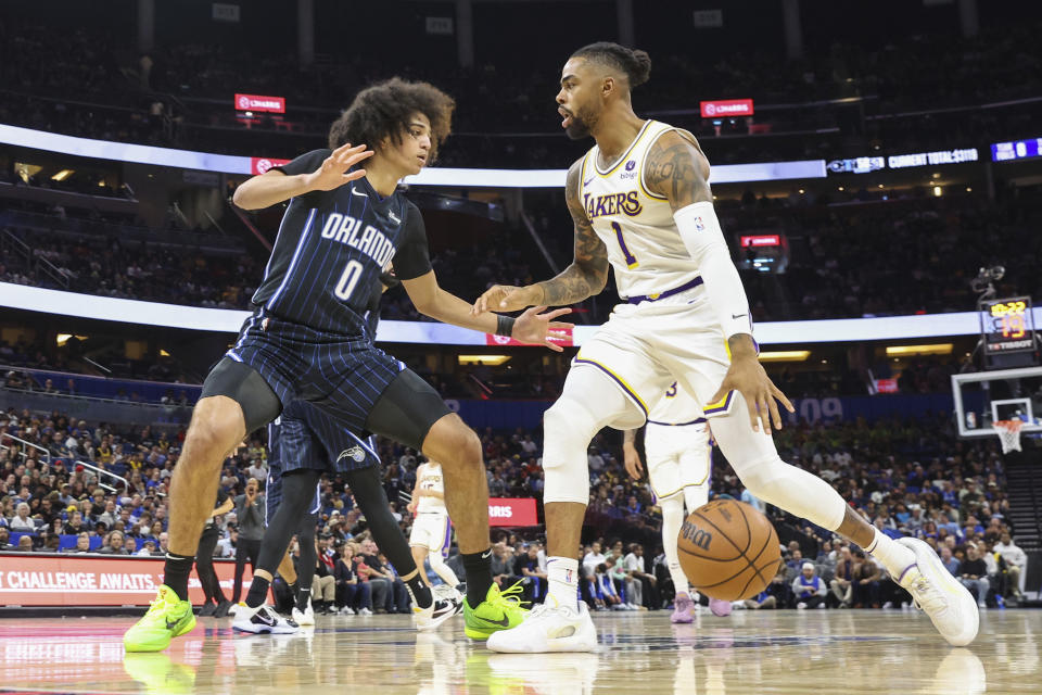 Orlando Magic guard Anthony Black, left, defends against Los Angeles Lakers guard D'Angelo Russell (1) during the first half of an NBA basketball game Saturday, Nov. 4, 2023, in Orlando, Fla. (AP Photo/Gary McCullough)