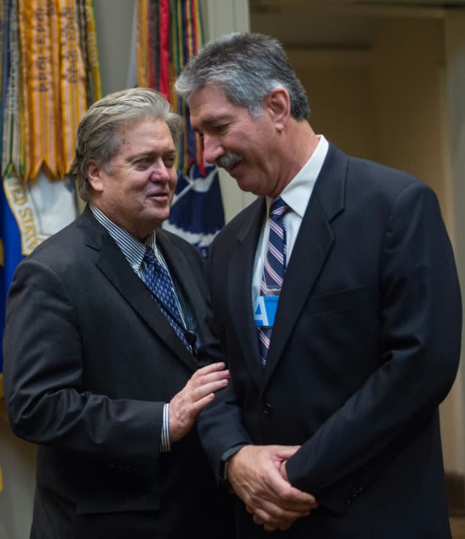 US President Donald Trump's Senior Counselor Steve Bannon (L) speaks with US Steel CEO Mario Longhi in the Roosevelt Room at the White House on January 23, 2017