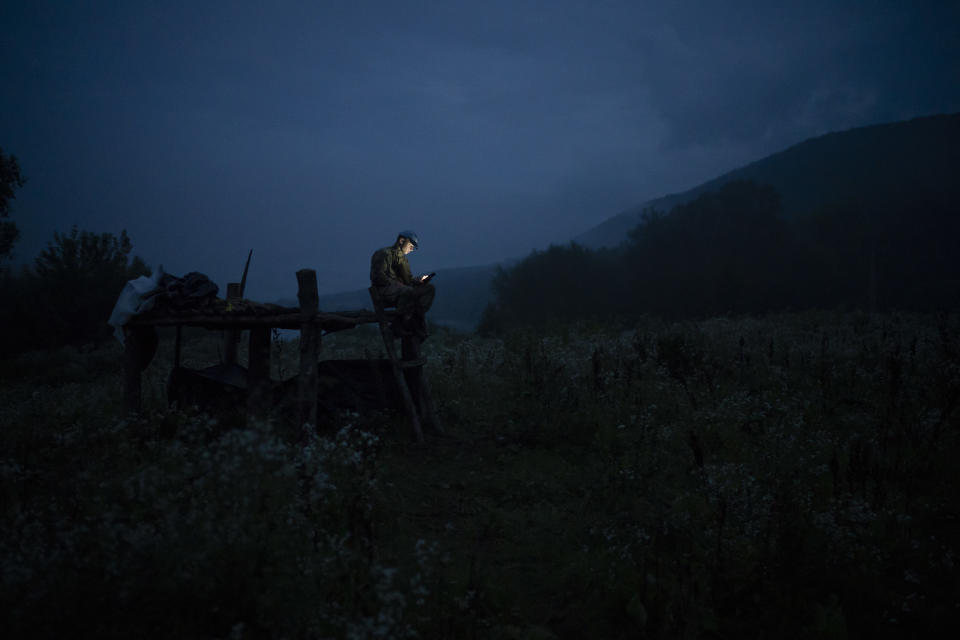 In this July 28, 2018 photo, a young participant of the "Temper of will" summer camp, organized by the nationalist Svoboda party, uses his cellphone to call his parents in a village near Ternopil, Ukraine. (AP Photo/Felipe Dana)