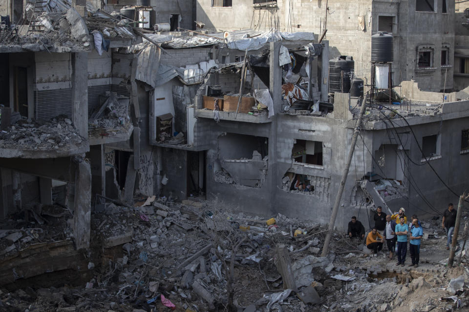 Palestinians inspect their destroyed houses following overnight Israeli airstrikes in town of Beit Hanoun, northern Gaza Strip, Friday, May 14, 2021. (AP Photo/Khalil Hamra)