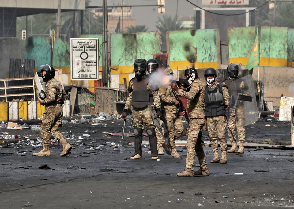 Riot police fire tear gas during clashes between Iraqi security forces and anti-Government protesters in Baghdad, Iraq, Thursday, Nov. 14, 2019. (AP Photo/Khalid Mohammed)