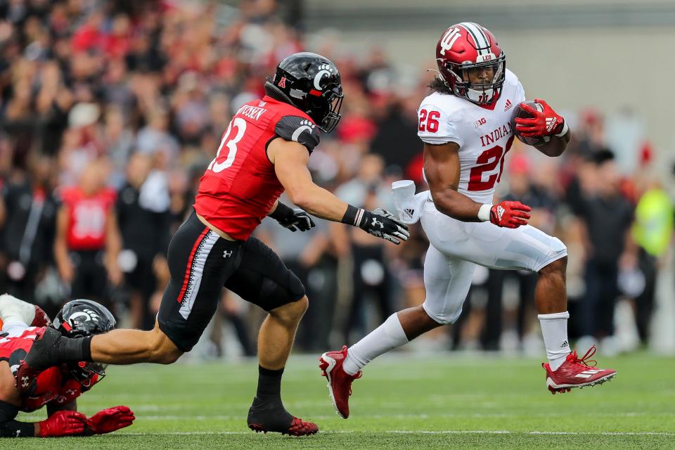 Sep 24, 2022; Cincinnati, Ohio, USA; Indiana Hoosiers running back Josh Henderson (26) runs with the ball against Cincinnati Bearcats linebacker Ty Van Fossen (13) in the first half at Nippert Stadium.