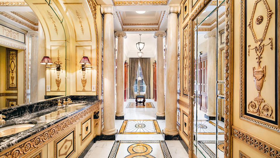 The luxe bathroom with double sinks, a black marble countertop and Italian-baroque details. - Credit: Travis Mark