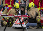 Rescue workers help an injured person after a car crashed into a crowd of people in central Berlin, Germany, Wednesday, June 8, 2022. (AP Photo/Michael Sohn)