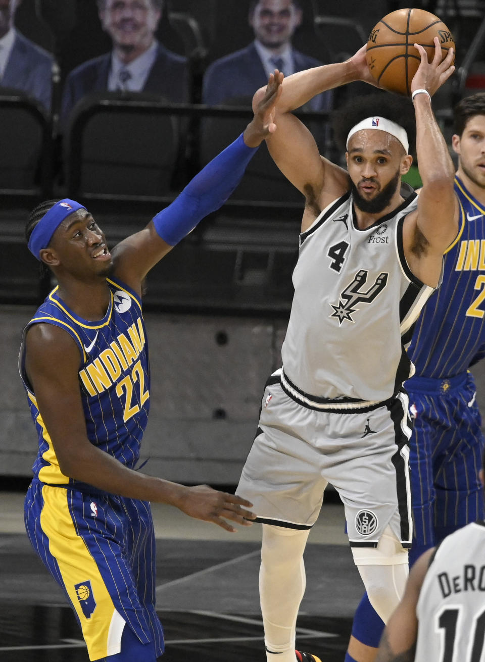 San Antonio Spurs' Derrick White (4) looks to pass as he is defended by Indiana Pacers' Caris LeVert during the second half of an NBA basketball game on Saturday, April 3, 2021, in San Antonio. (AP Photo/Darren Abate)
