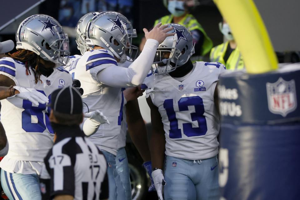 Dallas Cowboys wide receiver Michael Gallup (13) celebrates with quarterback Andy Dalton, center, and others after catching a touchdown pass in the first half of an NFL football game against the Philadelphia Eagles in Arlington, Texas, Sunday, Dec. 27. 2020. (AP Photo/Ron Jenkins)