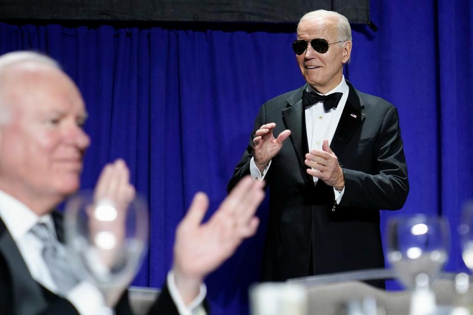 President Joe Biden wears sunglasses after making a joke about becoming the "Dark Brandon" persona during the White House Correspondents' Association dinner at the Washington Hilton in Washington, Saturday, April 29, 2023. John F. Lansing, President and CEO of NPR, is at left. (AP Photo/Carolyn Kaster)