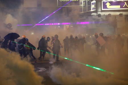 Anti-extradition bill protesters are seen among the smoke during a protest in Causeway Bay, Hong Kong