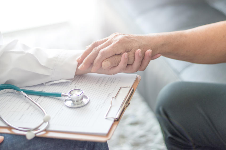 Parkinson and alzheimer female senior elderly patient with caregiver in hospice care. Old woman holding hand with doctor physician.