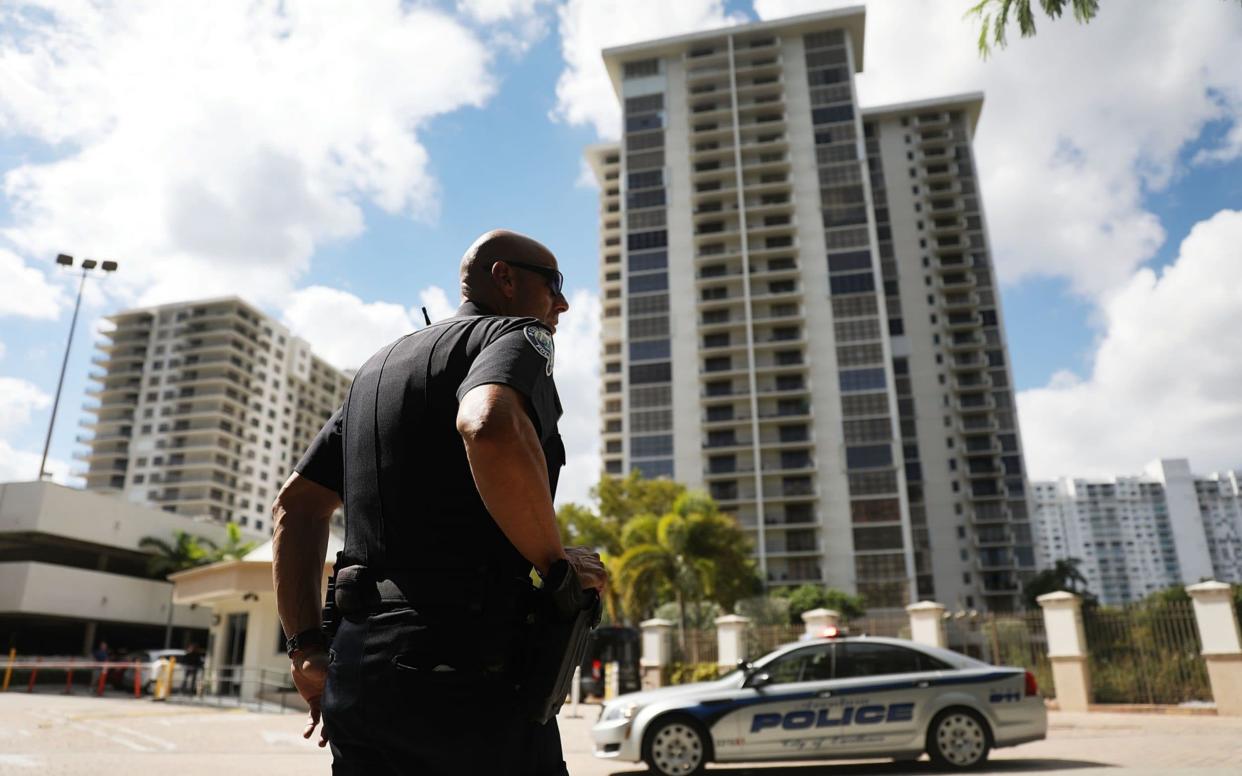 An Aventura City police officer stands across the street from the condo building that has a connection to alleged bomber Cesar Sayoc  - Getty Images North America