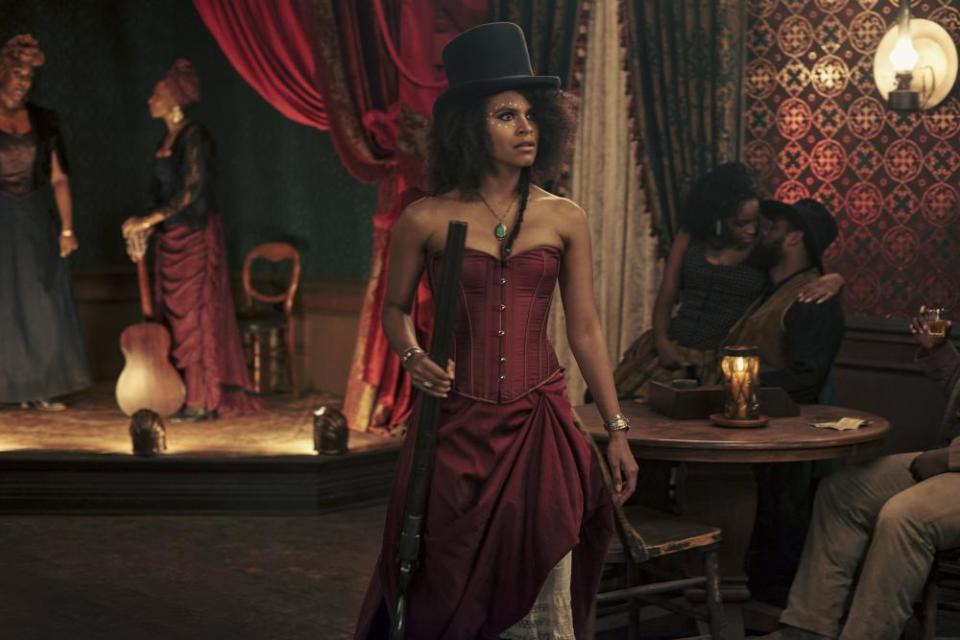 Zazie Beetz, in a corseted dress, as Stagecoach Mary