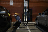 Jesus Ramirez wears a face mask while washing his car during the coronavirus pandemic in the Vermont Square neighborhood of Los Angeles, Thursday, May 21, 2020. While most of California took another step forward to partly reopen in time for Memorial Day weekend, Los Angeles County didn't join the party because the number of coronavirus cases has grown at a pace that leaves it unable to meet even the new, relaxed state standards for allowing additional businesses and recreational activities. (AP Photo/Jae C. Hong)