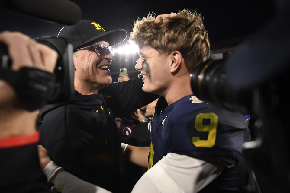 Michigan head coach Jim Harbaugh, left, celebrates with quarterback J.J. McCarthy (9) after an overtime win over Alabama at the Rose Bowl CFP NCAA semifinal college football game Monday, Jan. 1, 2024, in Pasadena, Calif. (AP Photo/Kyusung Gong)