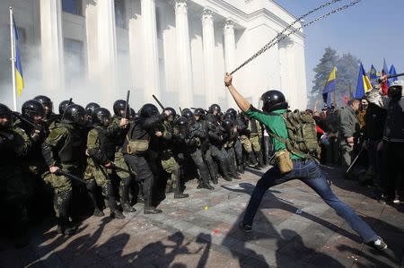 Radical protesters (R) clash with Interior Ministry and law enforcement members on the Day of Ukrainian Cossacks, marked by activists and supporters of the All-Ukrainian Union Svoboda (Freedom) Party and far-right activists and nationalists to honour the role of the movement in the history of Ukraine, during a rally near the parliament building in Kiev, October 14, 2014. REUTERS/Valentyn Ogirenko