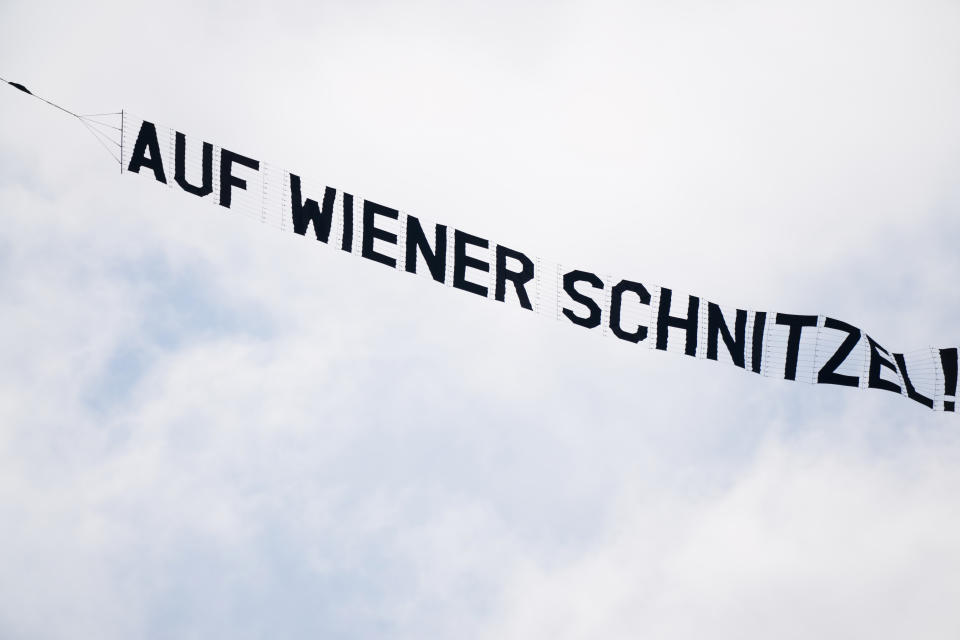 An airplane with a message for the Austrian team, combing the German for goodbye with their Wiener Schnitzel dish, flies over the training of the Netherlands team in Zeist, Netherlands, Wednesday, June 16, 2021, a day before the Euro 2020 soccer championship group C match between The Netherlands and Austria (AP Photo/Peter Dejong)