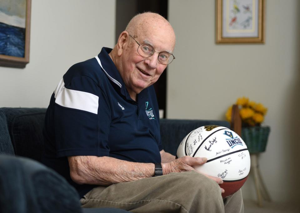 Longtime Wilmington sports broadcaster Wayne Jackson holds a basketball signed by the UNCW women's basketball team at his home in Wilmington in 2020.